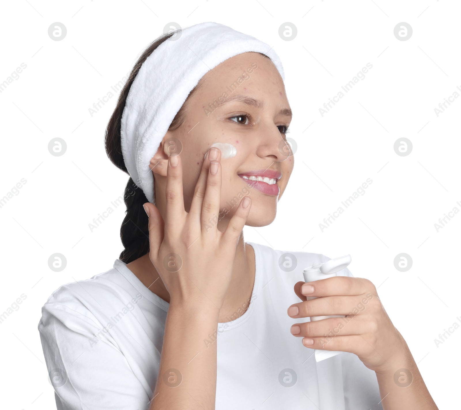 Photo of Teenage girl with acne problem applying cream on white background