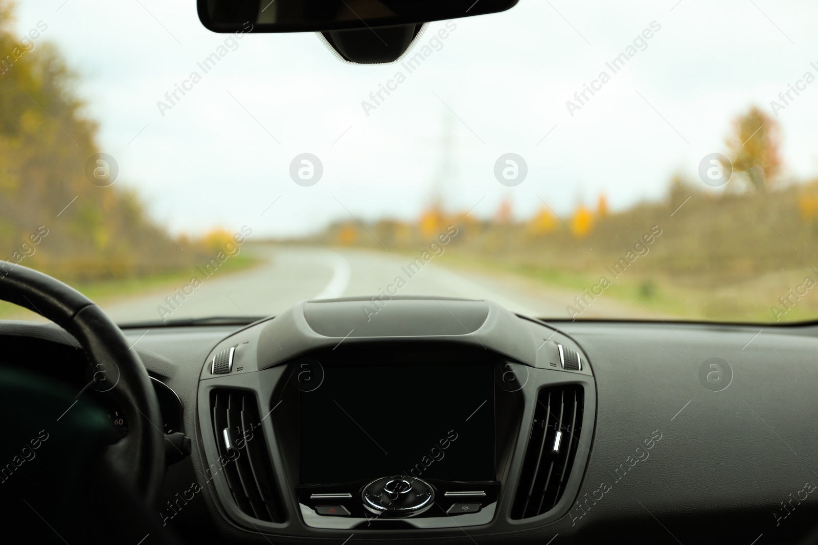 Photo of Steering wheel and dashboard in car. Road trip