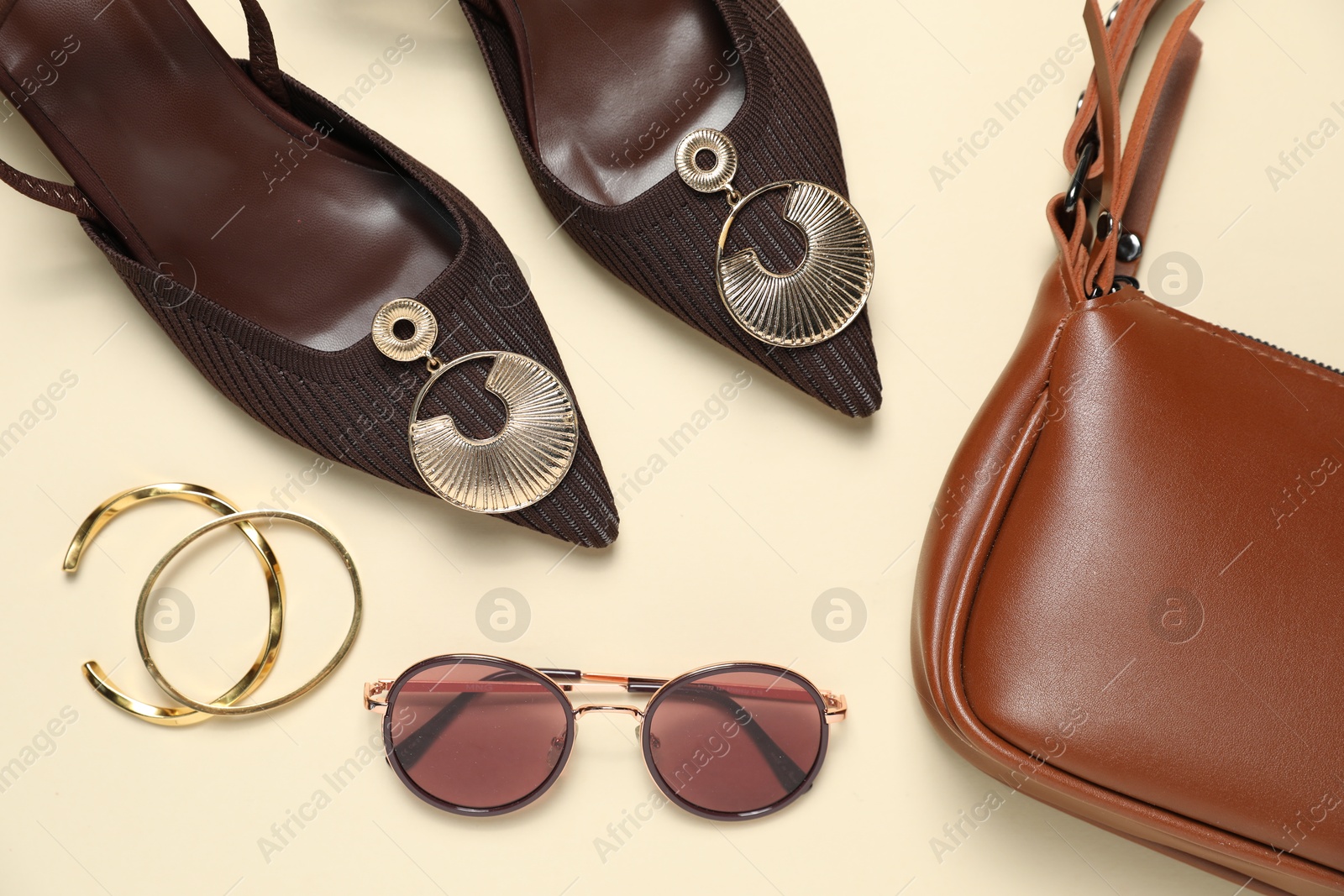 Photo of Flat lay composition with jewelry, accessories and shoes on beige background