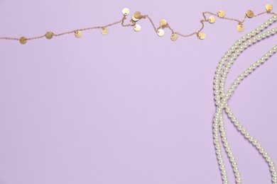 Photo of Beautiful pearl and golden necklaces on violet background, flat lay. Space for text