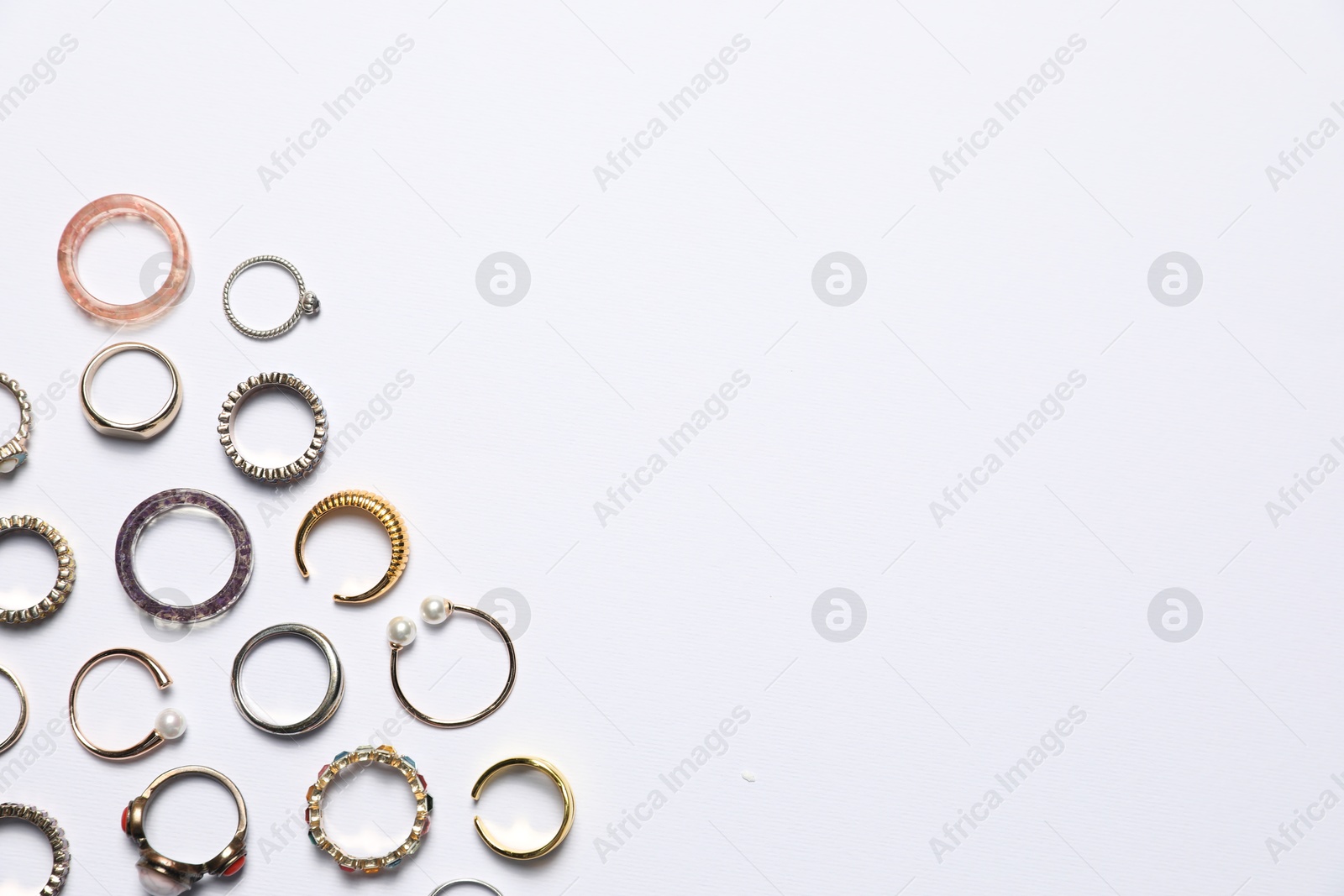 Photo of Many different rings on white background, flat lay. Space for text