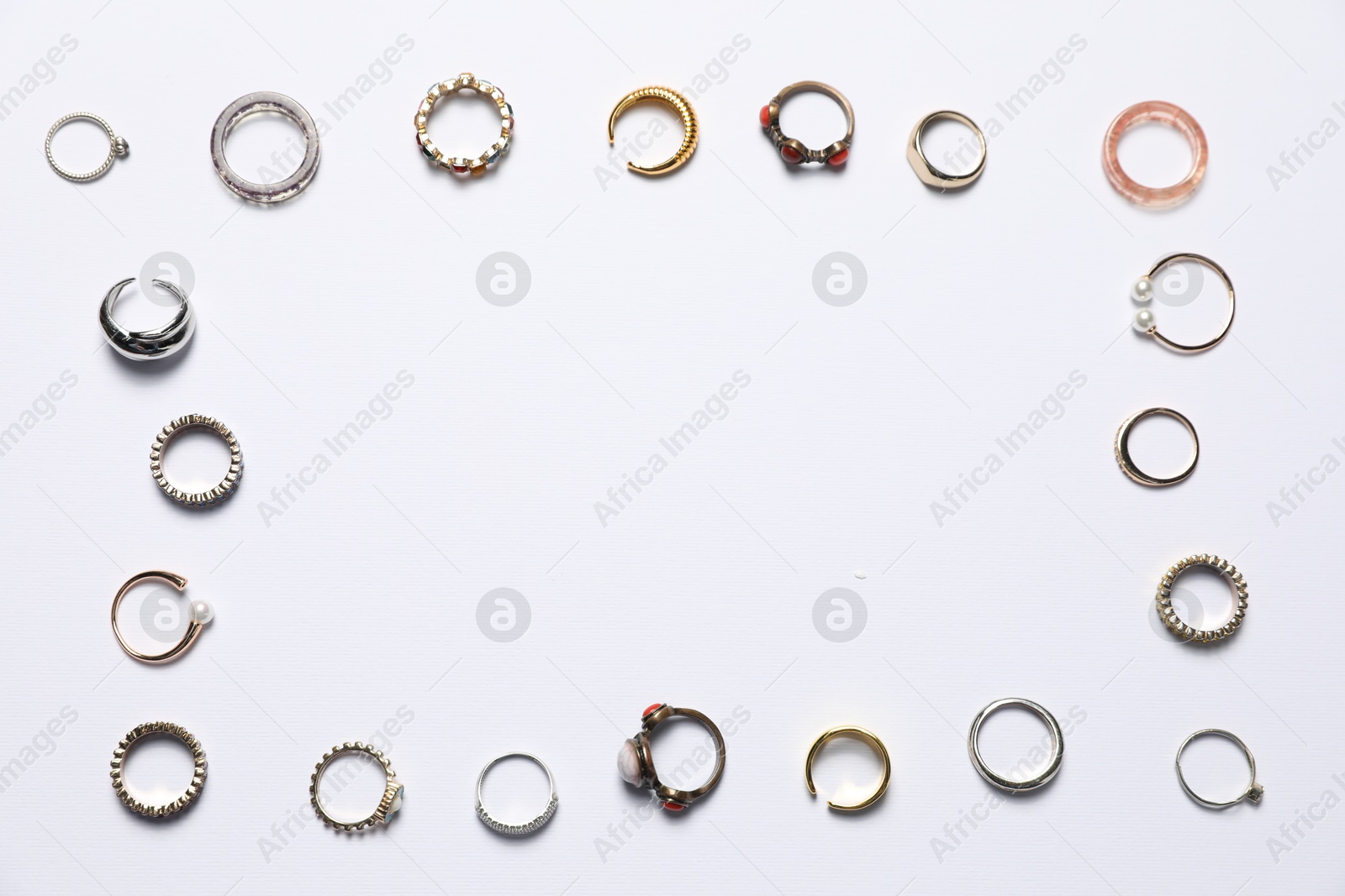 Photo of Frame made of many different rings on white background, flat lay. Space for text