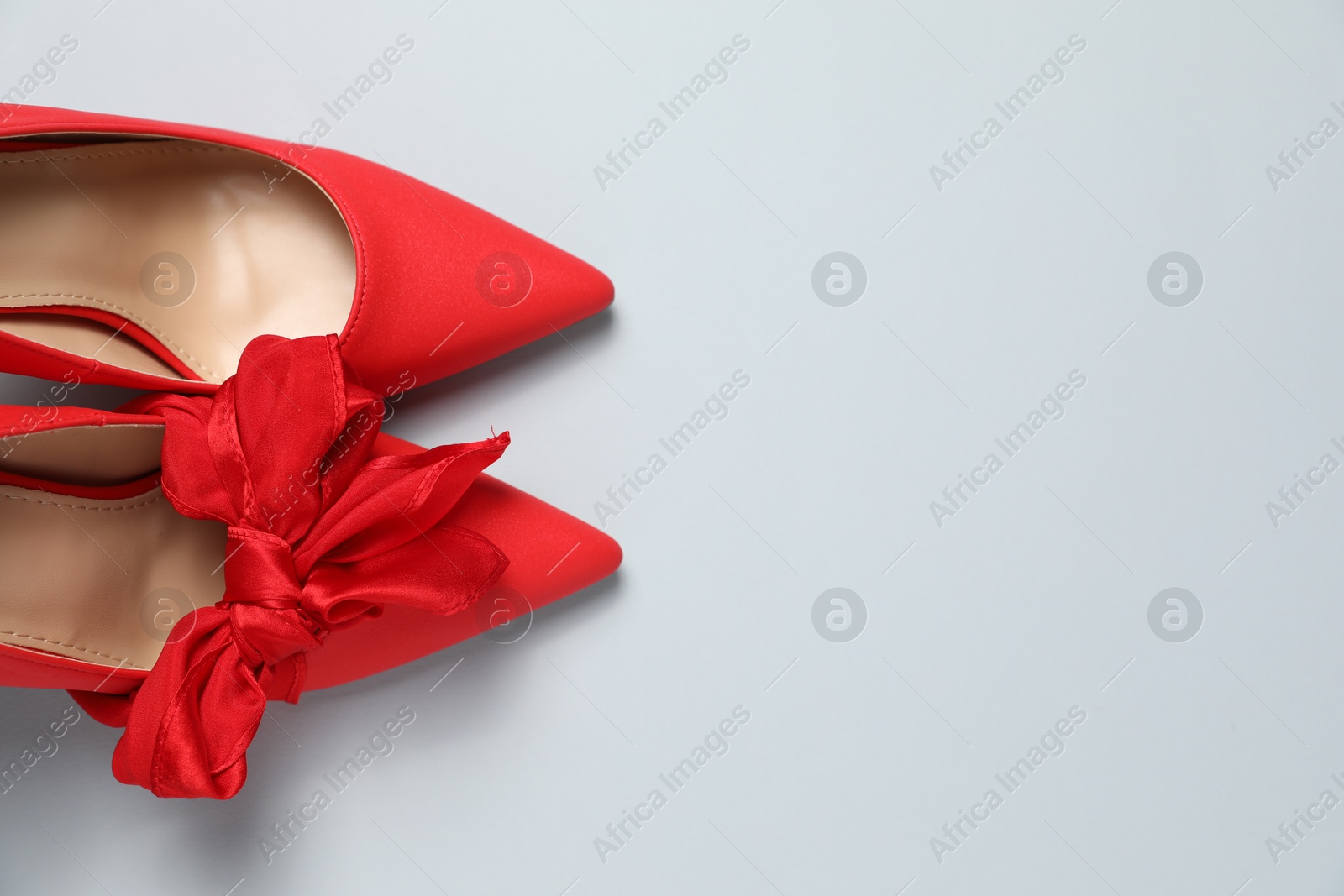 Photo of Stylish red women's shoes on light grey background, top view. Space for text