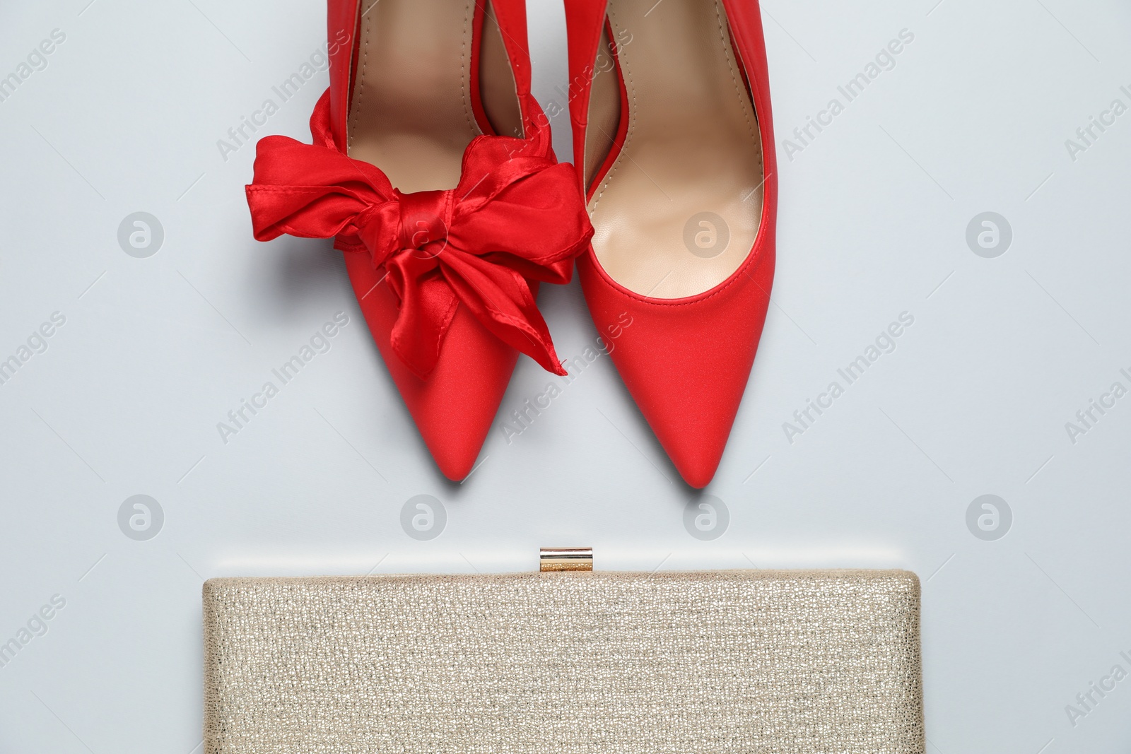 Photo of Stylish red women's shoes and purse on light grey background, flat lay