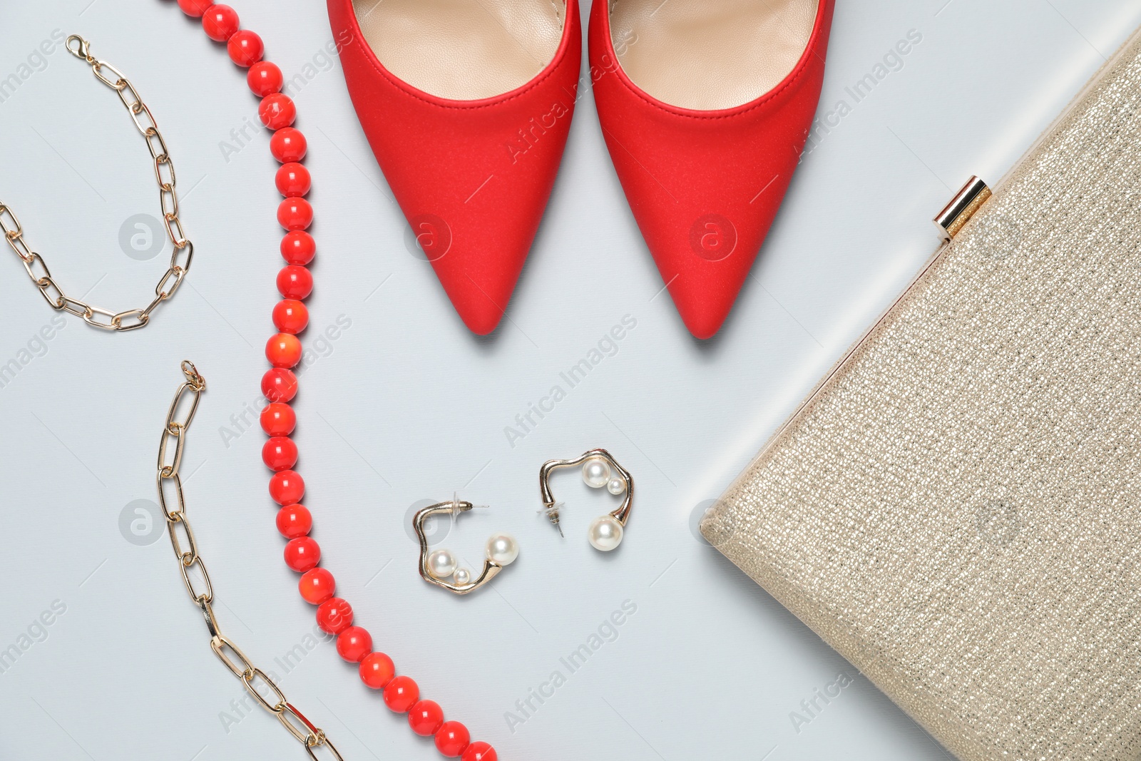 Photo of Stylish shoes, jewelry and purse on light grey background, flat lay