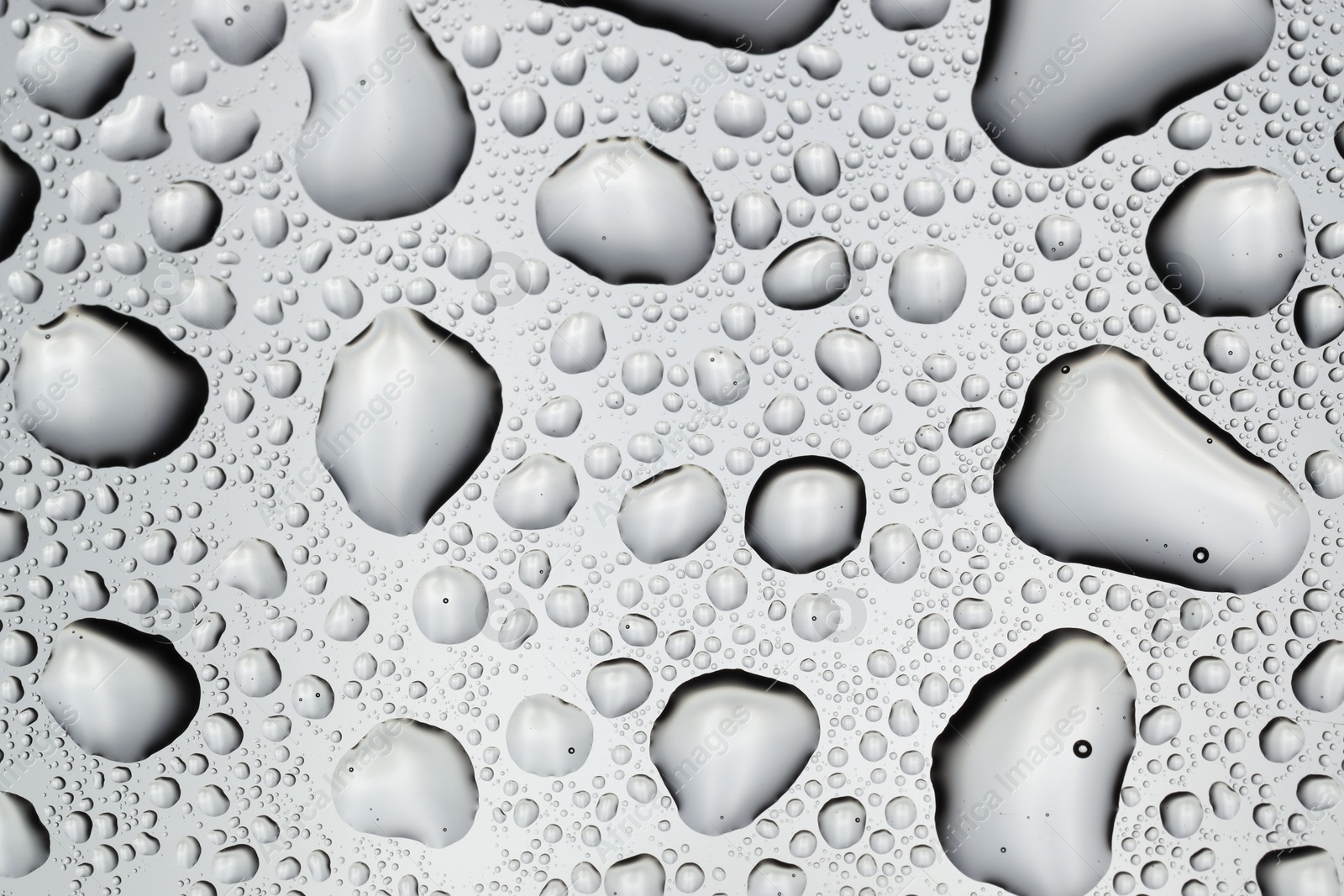 Photo of Water drops on light glass surface, top view