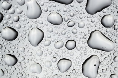 Water drops on light glass surface, top view