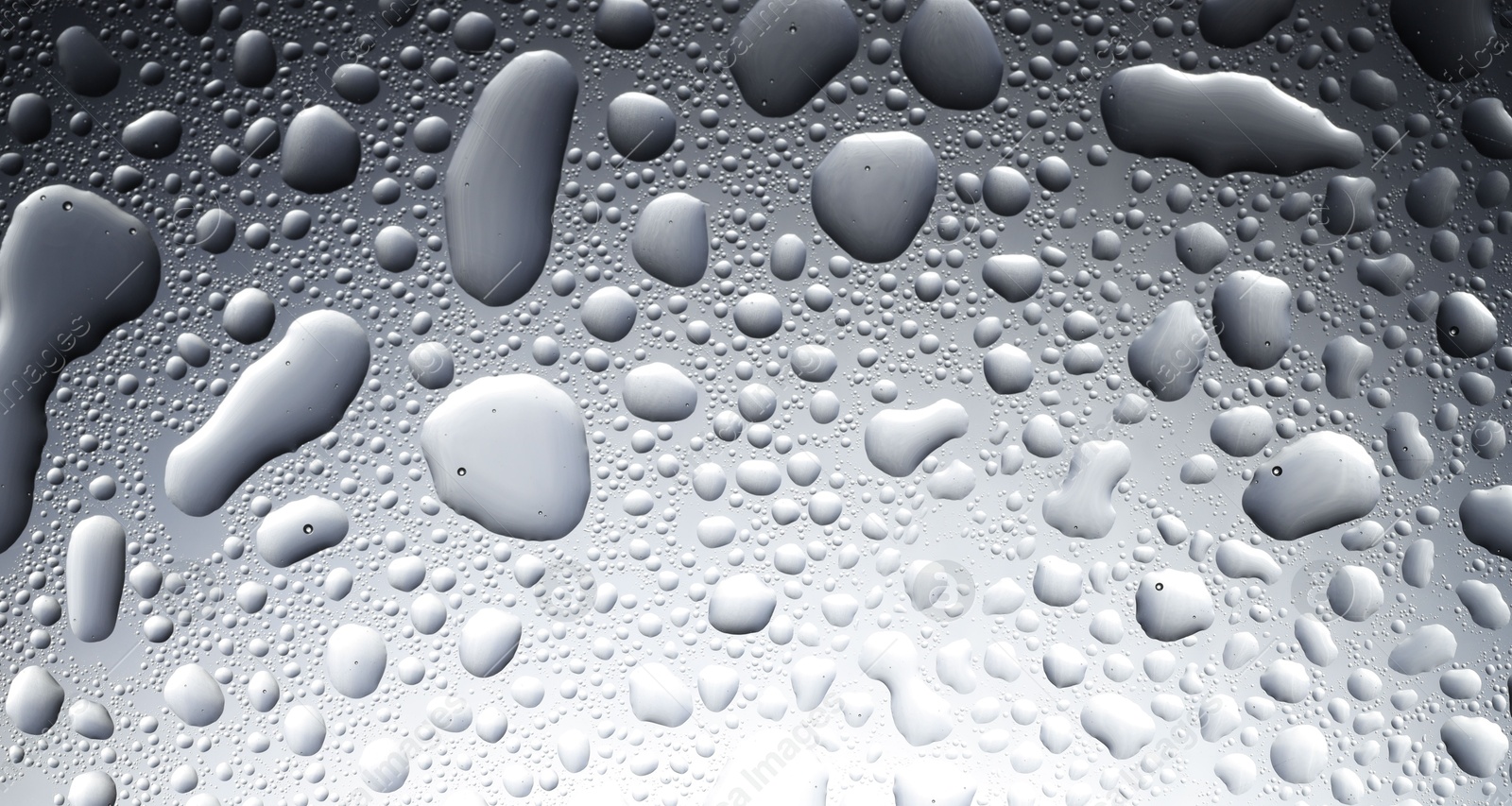 Photo of Water drops on grey glass surface, top view