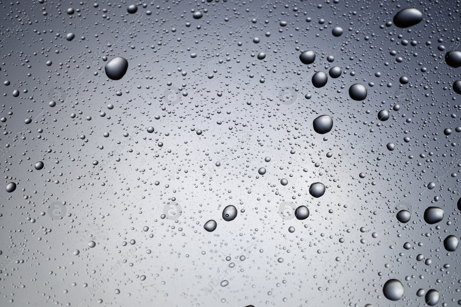 Photo of Water drops on grey glass surface, top view