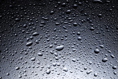 Water drops on dark glass surface, closeup