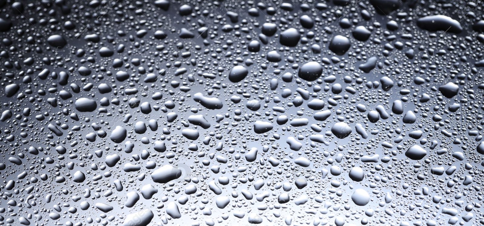 Photo of Water drops on glass surface, closeup view