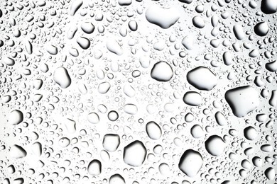 Photo of Water drops on light glass surface, top view