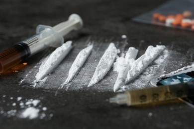 Photo of Drug addiction. Powder, syringes and credit card on gray textured table, closeup