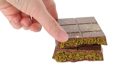 Photo of Woman taking piece of tasty Dubai chocolate with pistachios and knafeh on white background, closeup