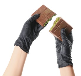 Photo of Woman holding pieces of tasty Dubai chocolate bar with pistachios and knafeh on white background, closeup