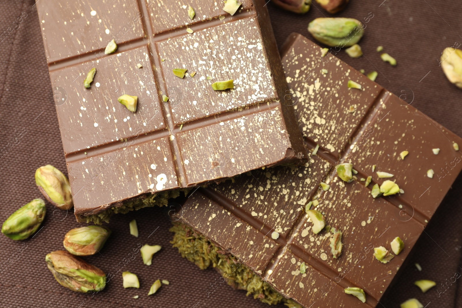 Photo of Pieces of tasty Dubai chocolate with pistachios and knafeh on napkin, top view