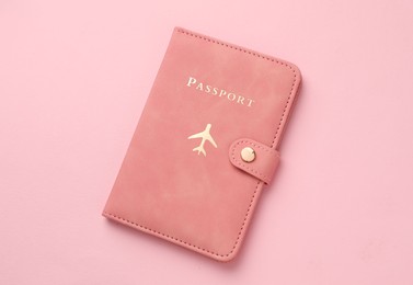 Photo of Passport in color cover on pink background, top view