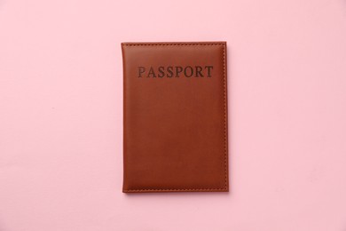 Photo of Passport in brown cover on pink background, top view