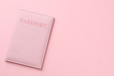 Photo of Passport in color cover on pink background, top view