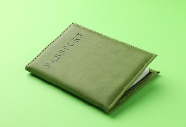 Photo of Passport in color cover on green background, closeup