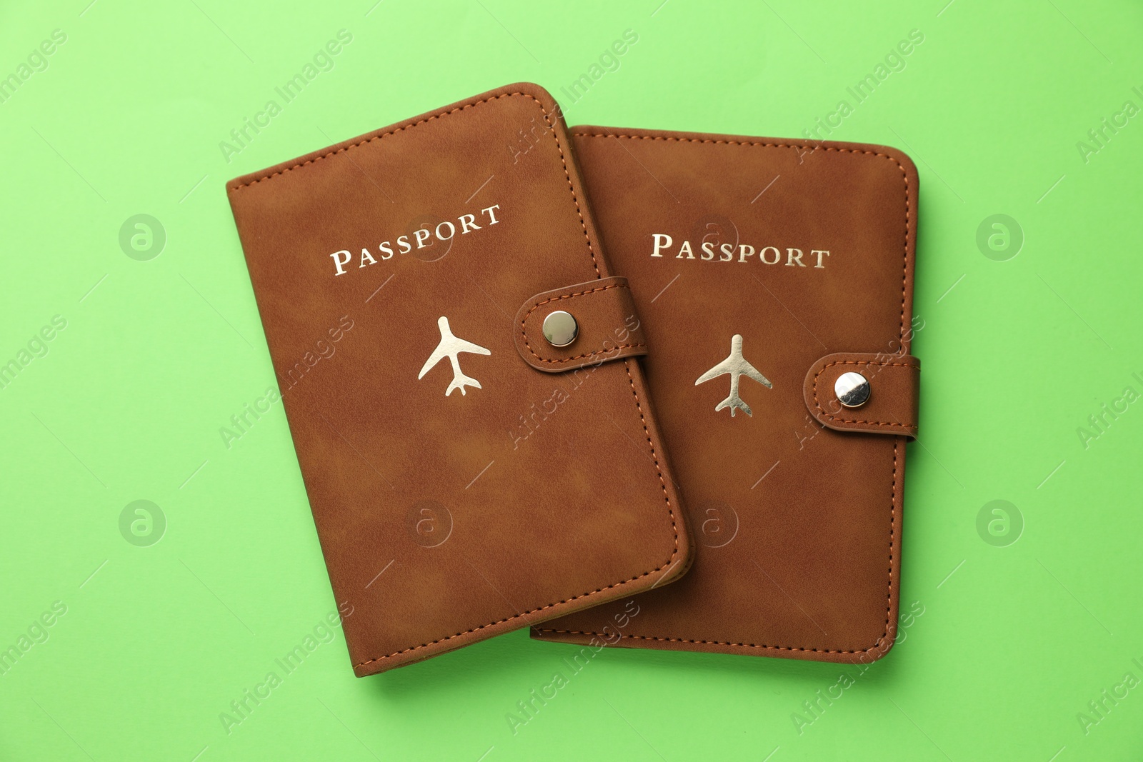 Photo of Passports in brown covers on green background, top view