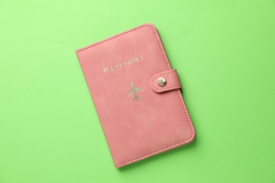 Photo of Passport in pink cover on green background, top view