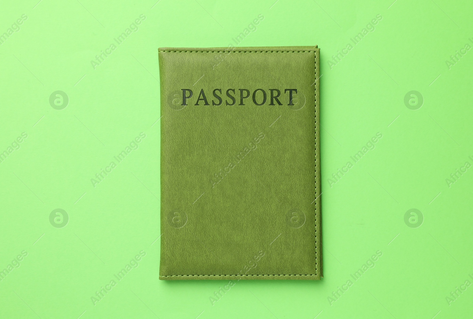 Photo of Passport in color cover on green background, top view