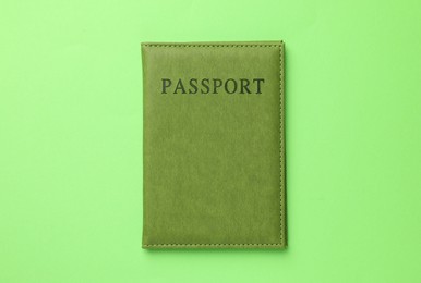 Photo of Passport in color cover on green background, top view