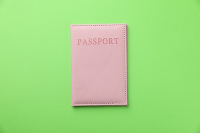 Photo of Passport in pink cover on green background, top view