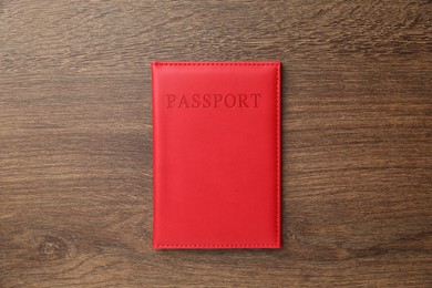 Photo of Passport in red cover on wooden table, top view