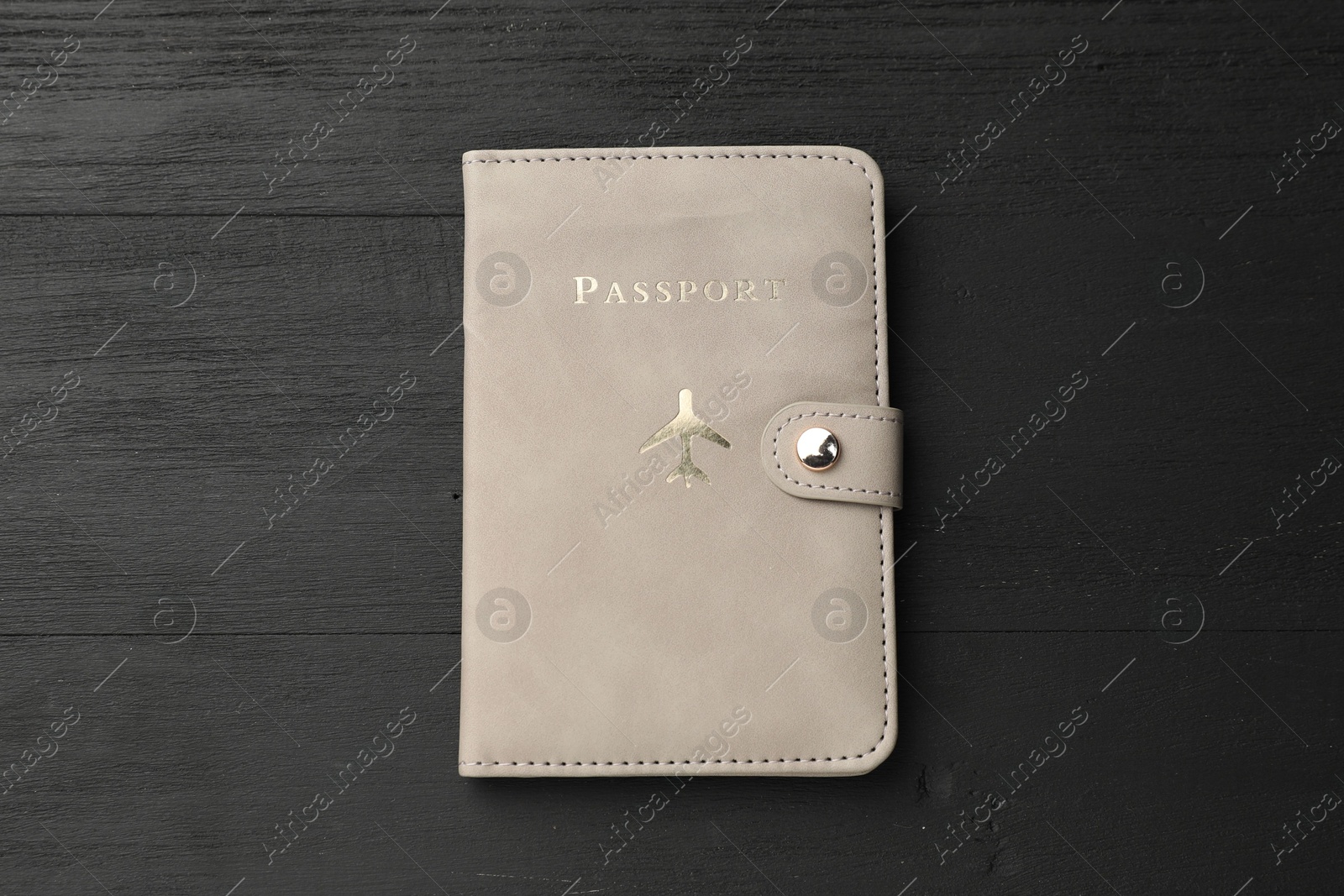 Photo of Passport in leather cover on black wooden table, top view