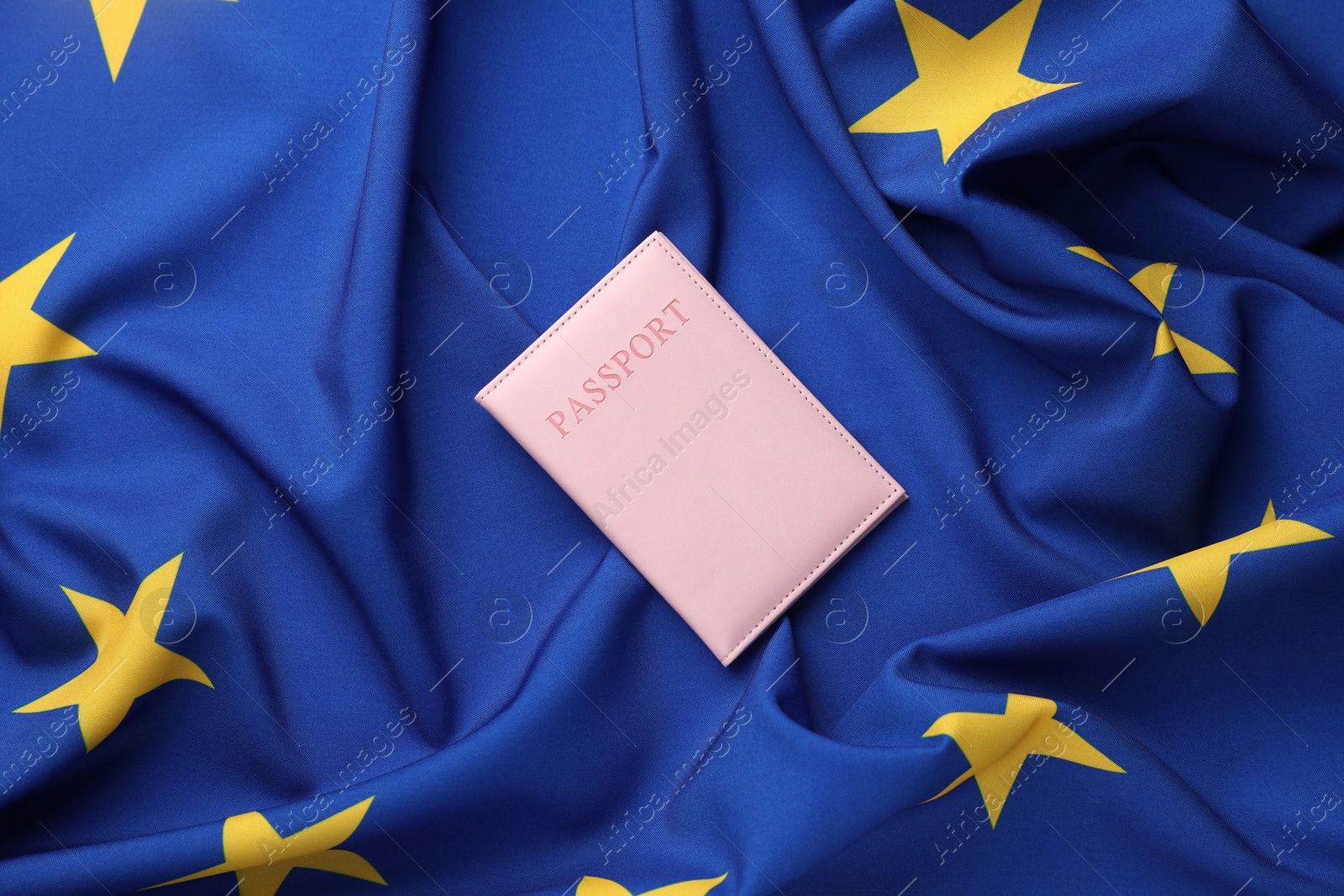 Photo of Passport in pink cover on flag of European Union, top view