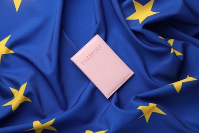 Photo of Passport in pink cover on flag of European Union, top view