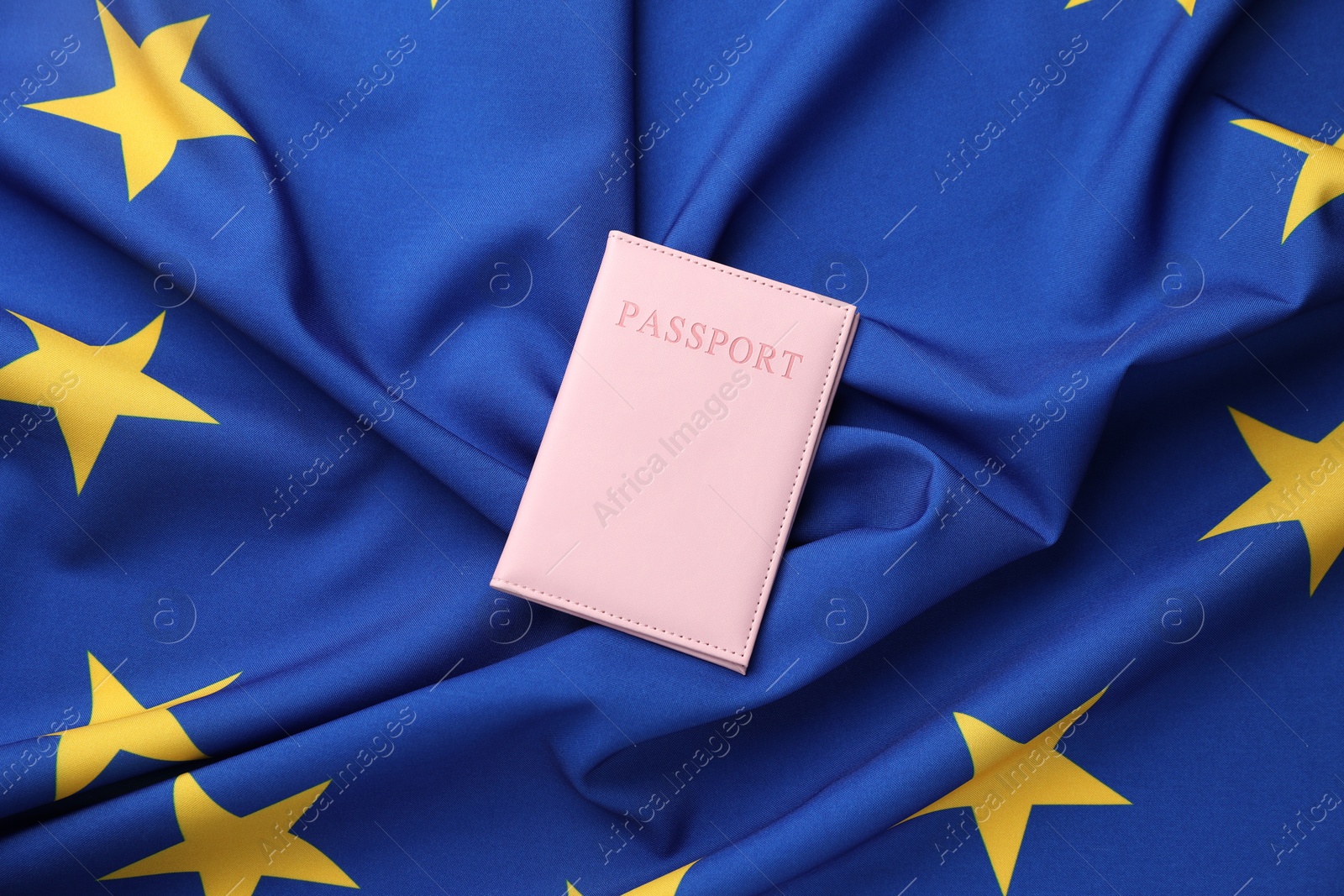 Photo of Passport in pink cover on flag of European Union, top view