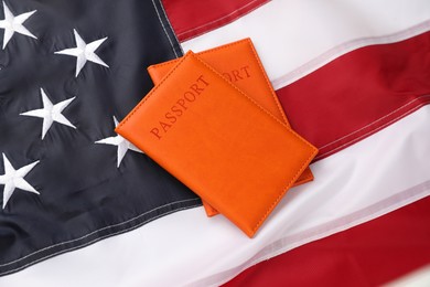 Photo of Passports in orange covers on flag of United States, above view