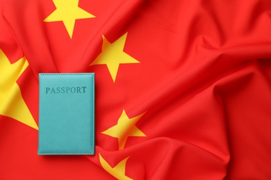 Photo of Passport in light blue cover on flag of China, top view. Space for text