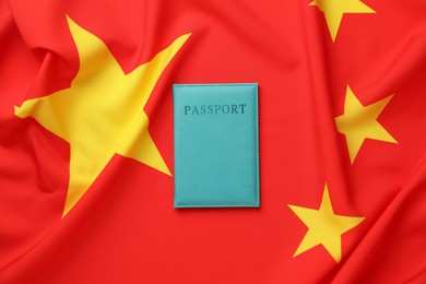 Photo of Passport in light blue cover on flag of China, top view