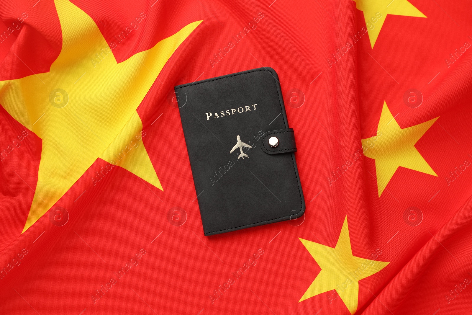 Photo of Passport in black cover on flag of China, top view