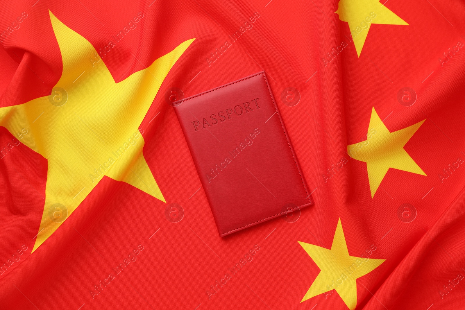 Photo of Passport in red cover on flag of China, top view