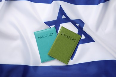 Photo of Passports in color covers on flag of Israel, top view