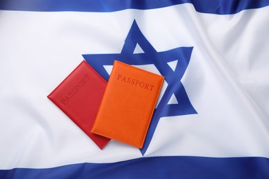 Photo of Passports in color covers on flag of Israel, top view