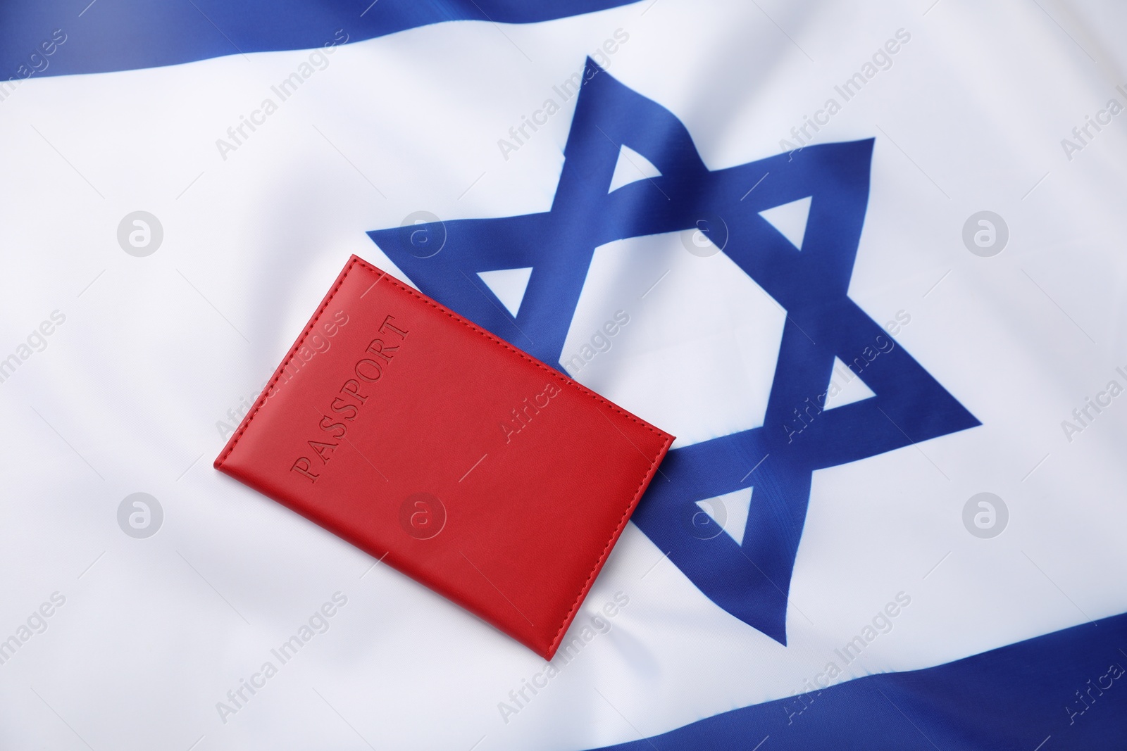 Photo of Passport in red cover on flag of Israel, top view