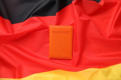 Photo of Passport in orange cover on flag of Germany, top view