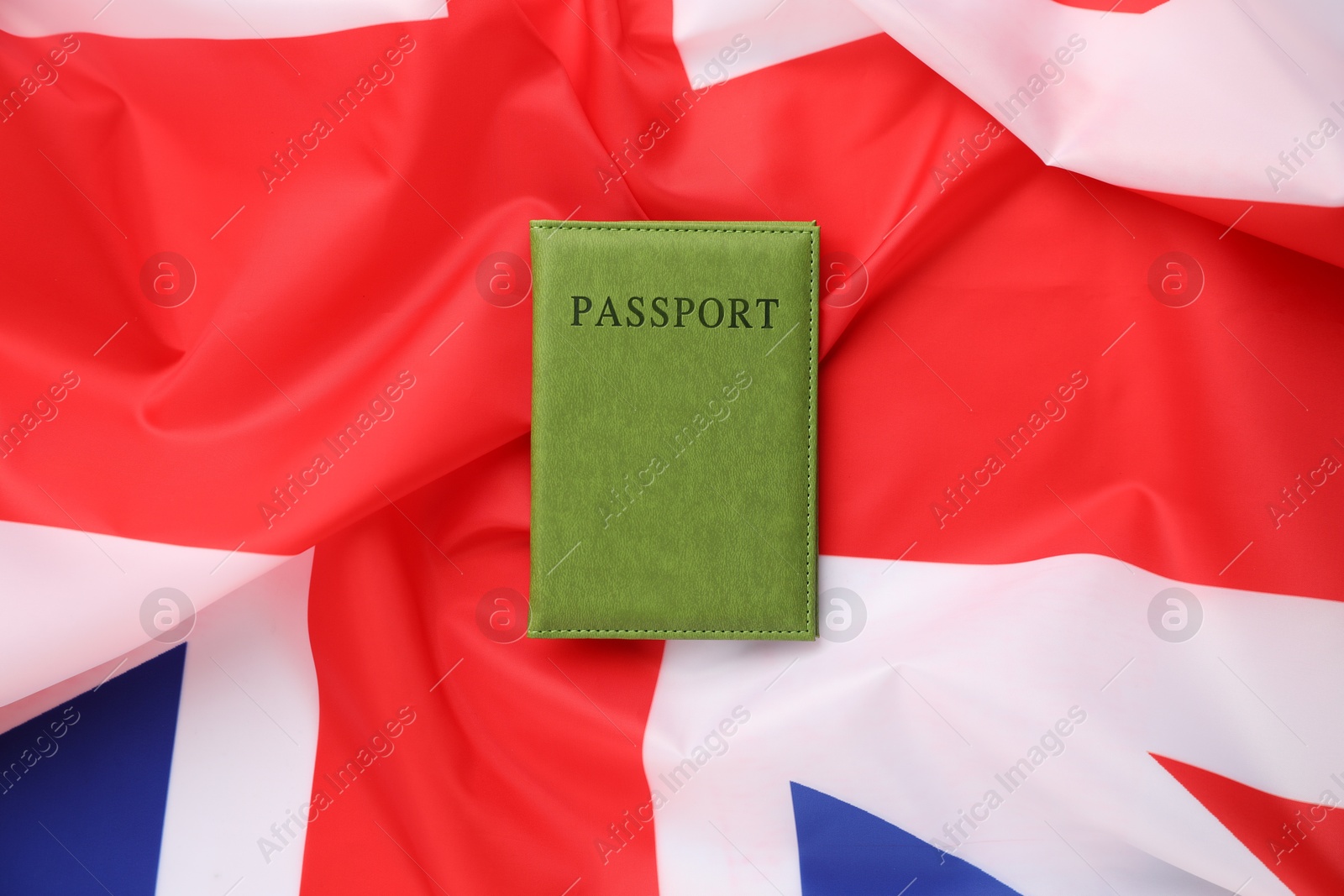 Photo of Passport in green cover on flag of United Kingdom, top view