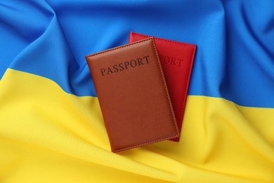 Photo of Passports in color covers on flag of Ukraine, top view