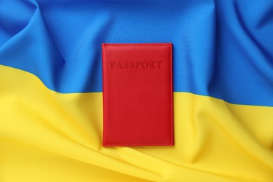 Photo of Passport in red cover on flag of Ukraine, top view