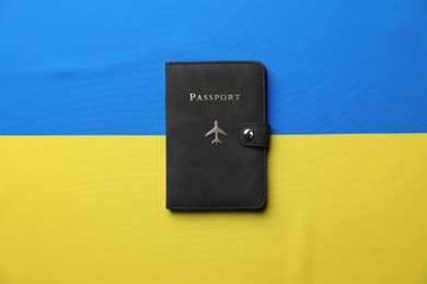 Photo of Passport in black cover on flag of Ukraine, top view