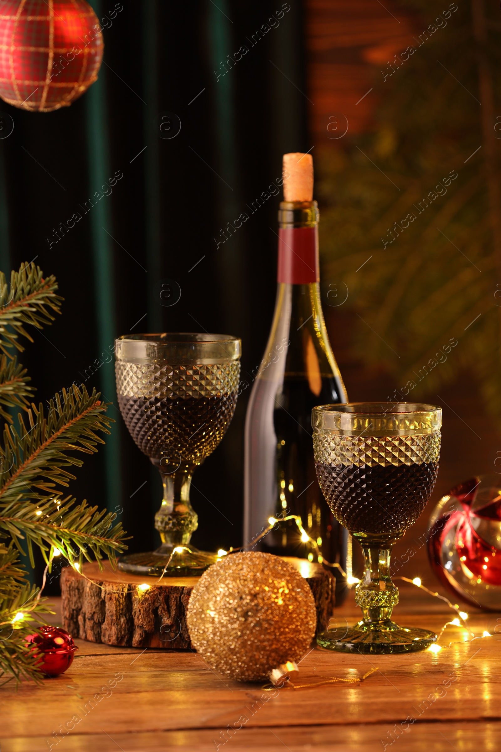 Photo of Red wine and beautiful Christmas decor on wooden table