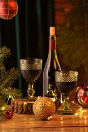 Photo of Red wine and beautiful Christmas decor on wooden table