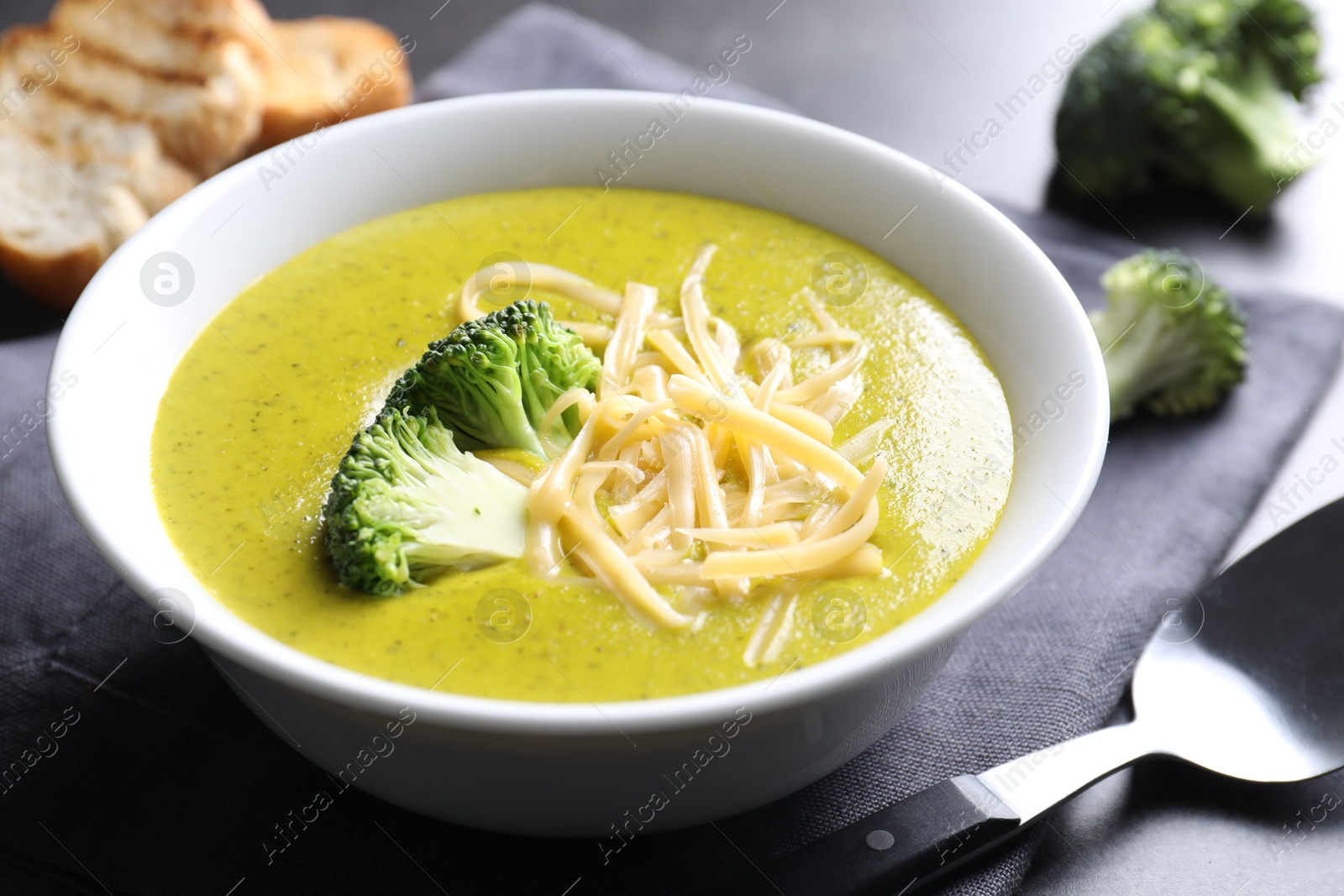 Photo of Delicious broccoli cream soup served on gray table, closeup